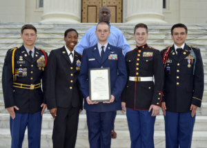 JROTC and CTE students pose for a picture with their instructor