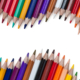 Colored pencils isolated on a white background with wave shaped space for your text